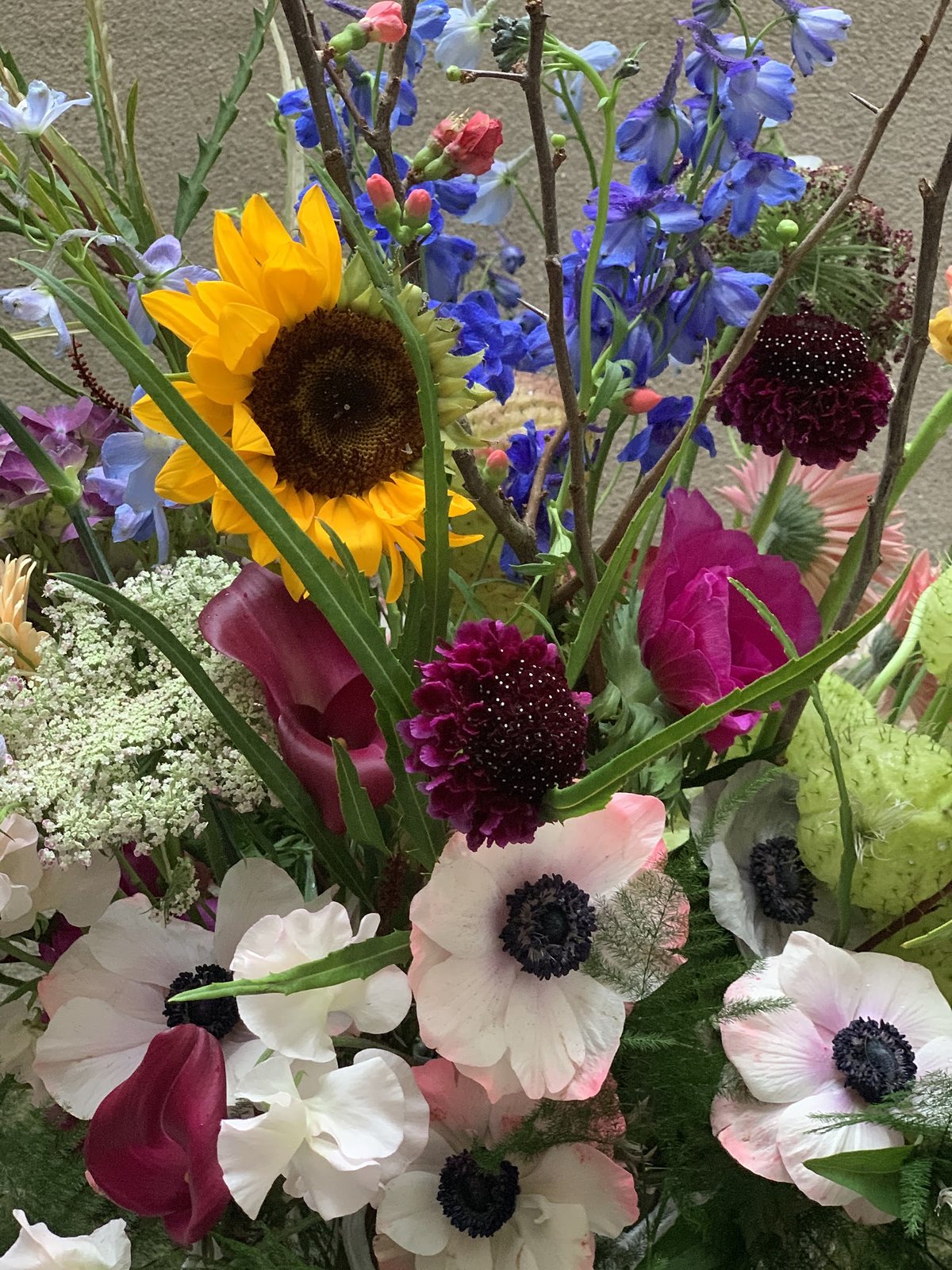 Bouquet champêtre de tournesols, d’anémones blanches et de dahlias sombres